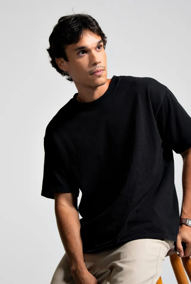 Lipe de camiseta preta, sentado, olhando para o alto