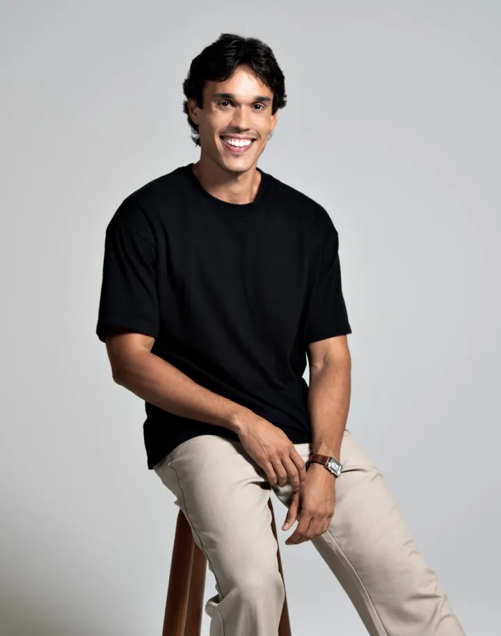 Lipe sentado num banco, sorrindo